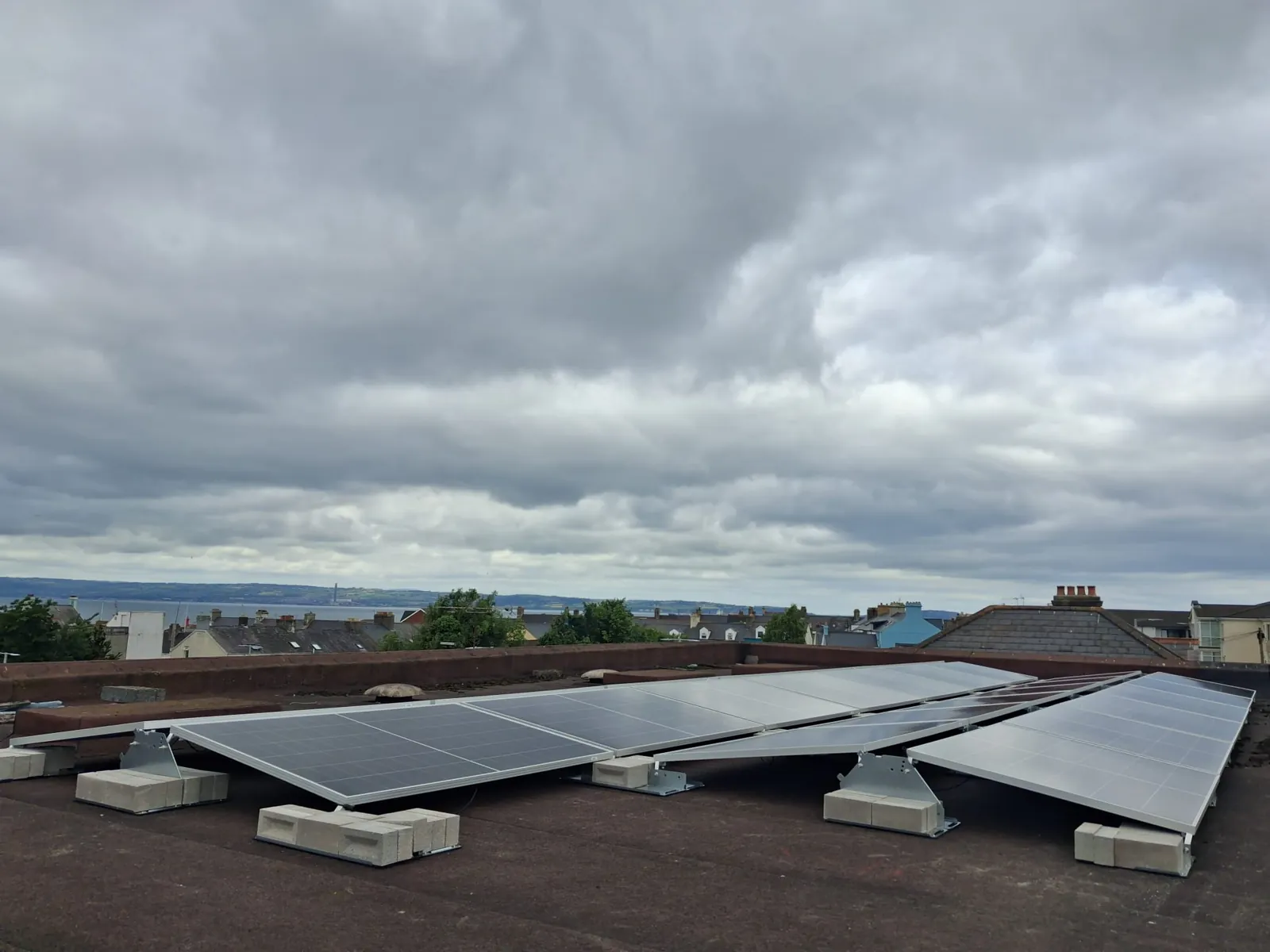 Rows of solar panels on ballasted mounting frames on a flat roof