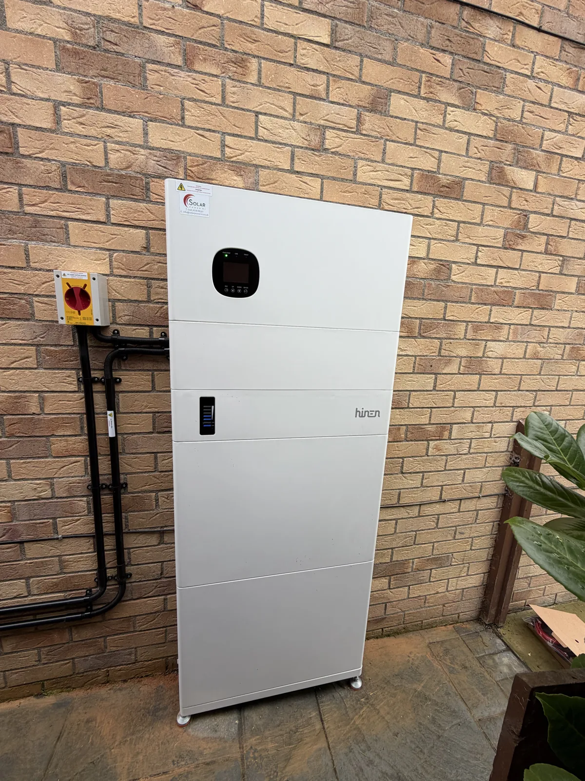 Hinen all-in-one battery on a brick wall