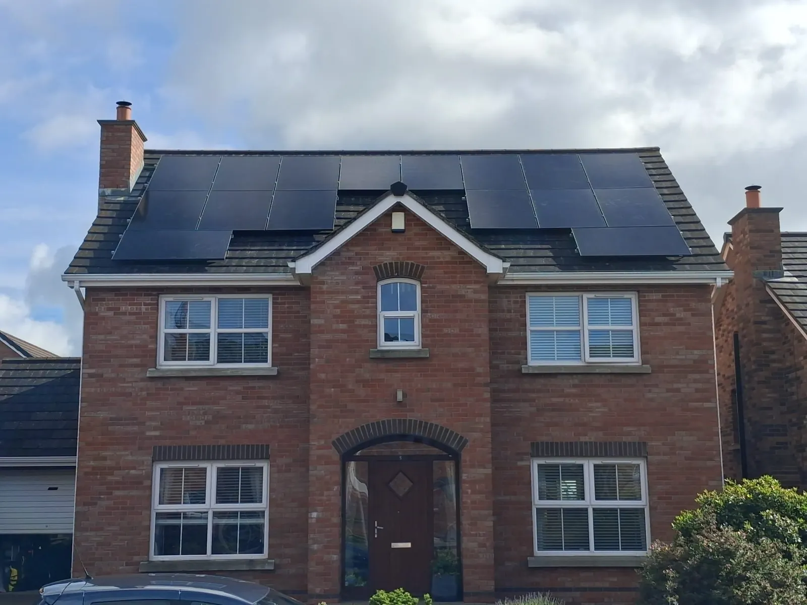 Black solar panels on a red-brick home